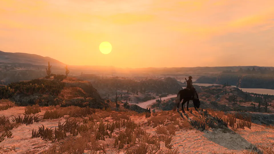 A lone rider on horseback watches the sun set over desert hills and a winding river in Red Dead Redemption on Nintendo Switch 2