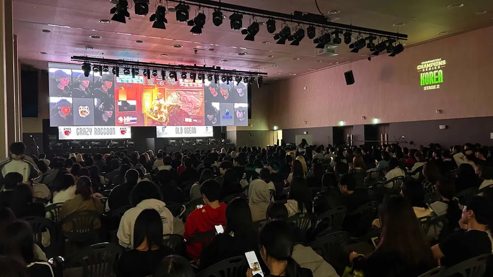 Fans watch an OWCS match on a big screen at a live event