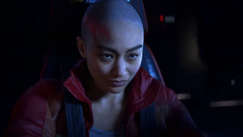 Jordan A. Mun in a red jacket sitting in a dark spaceship cockpit