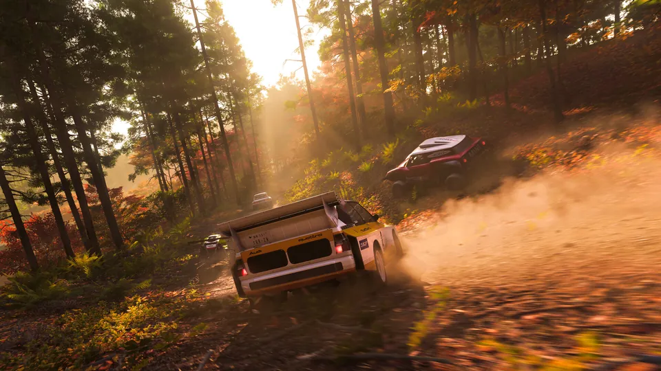 A rally car kicks up dust on a forest dirt road at sunset