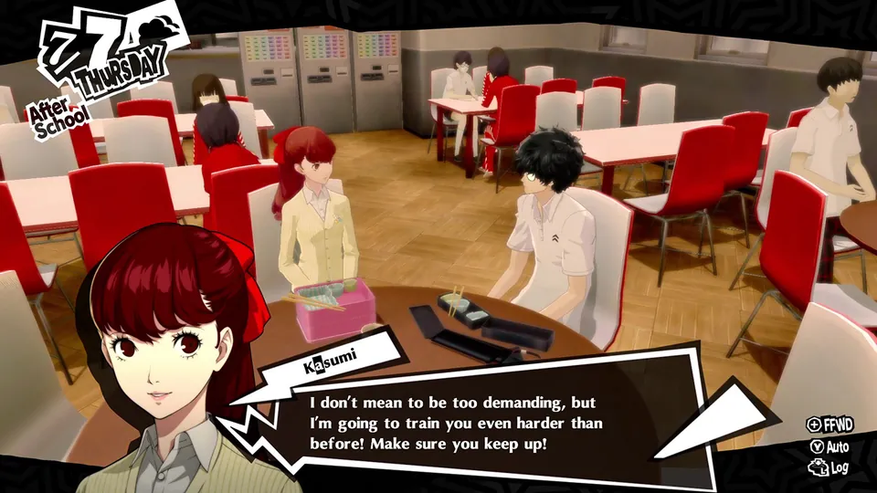 A student with long red hair talks to a classmate in a school cafeteria after class