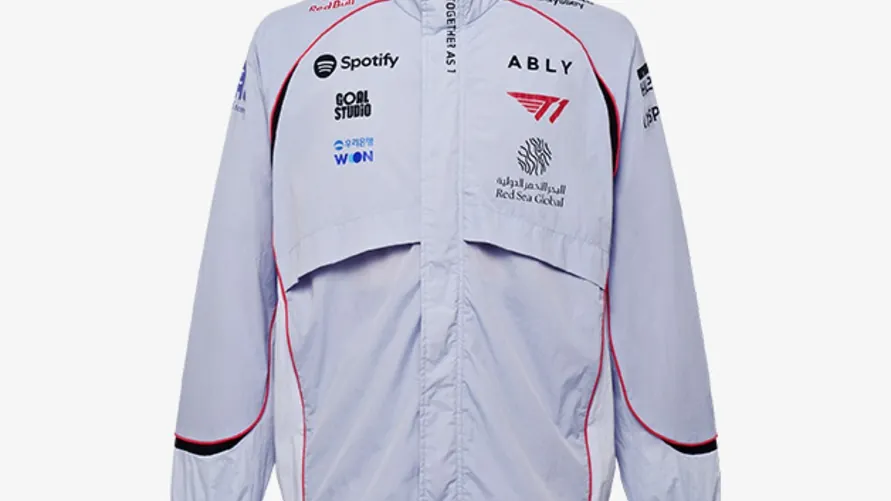 The front of T1's light gray 2026 International Jacket with a stand collar, red trim and sponsor logos
