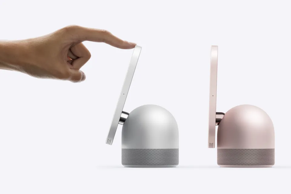 A finger tilting the HomeView screen on its hinge, next to a rose pink HomeView