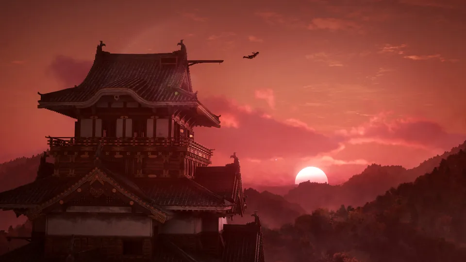 A Japanese castle keep silhouetted against a red sunset sky