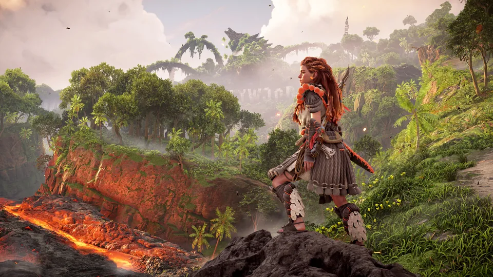 Aloy stands on a rocky ledge above glowing lava and a lush jungle in Horizon Forbidden West