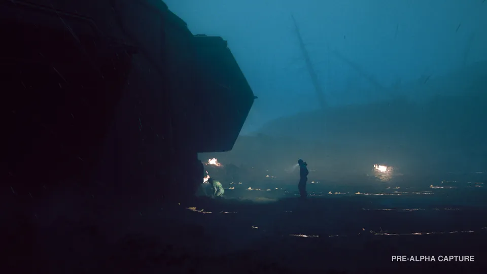 A lone figure stands near small fires beside the dark hull of a crashed ship on a misty planet