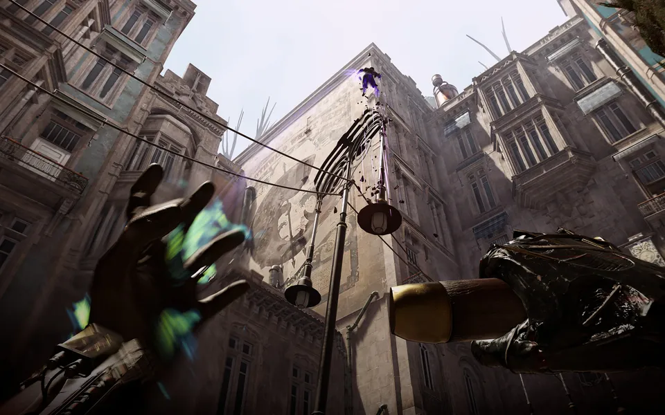 A hand glows with a supernatural power while looking up at a tall stone building and rooftop lines in Dishonored: Death of the Outsider