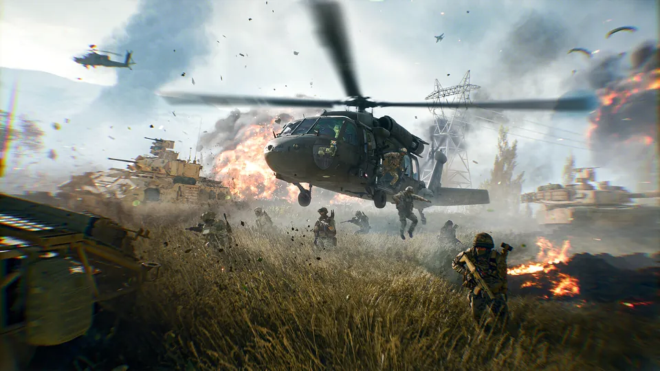 A military helicopter hovers low over a burning grass field as soldiers and tanks advance in Battlefield 6