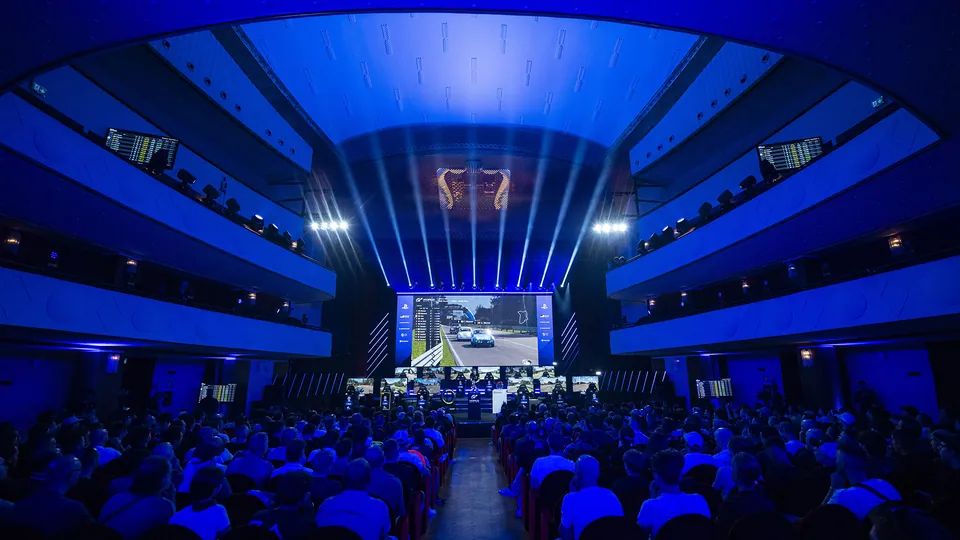 Teatro Lirico Giorgio Gaber in Milan lit in blue, with the race on a big screen above the drivers for Round 1
