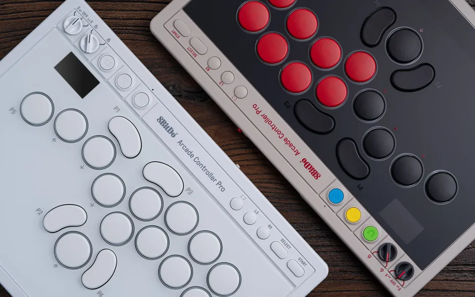 White Edition of the 8BitDo Arcade Controller Pro lying next to the gray N Edition with red and black buttons