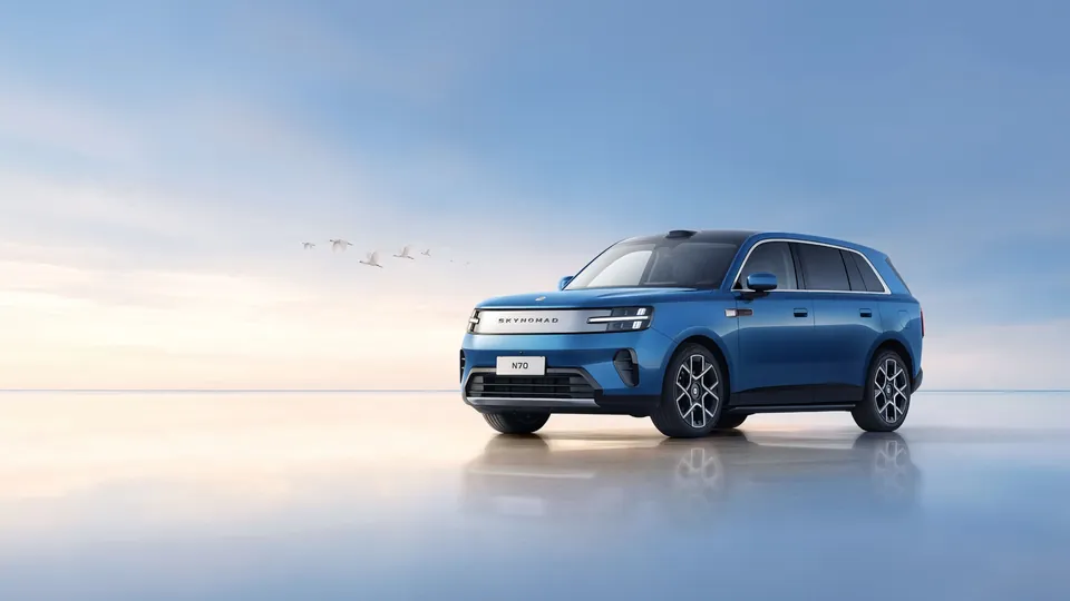 A blue Xiaomi Pengcheng N70 SUV parked on a reflective salt flat under a pale sky