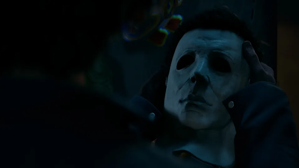 Halloween: The Game screenshot: Michael Myers in the white mask in a dark room