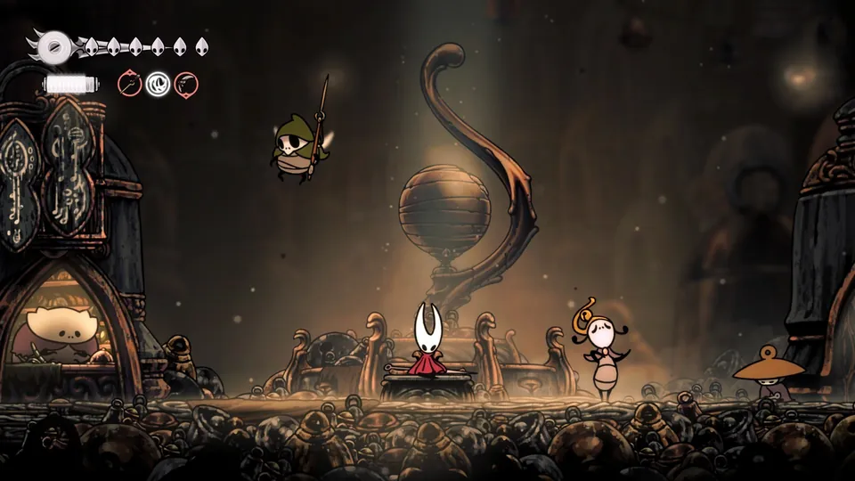 Hornet stands in a candlelit hall full of bug townsfolk in Hollow Knight: Silksong