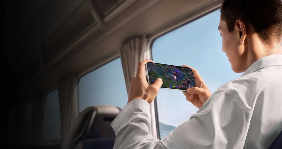 A man plays a game on an Oppo Find X10 Pro Max on a train