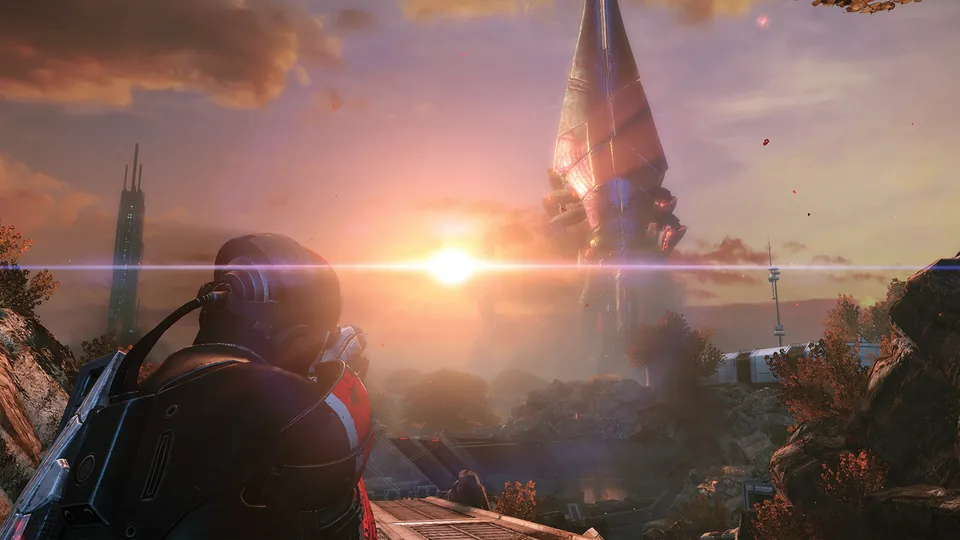 A soldier in N7 armor looks out at a glowing alien spire at sunset in Mass Effect Legendary Edition