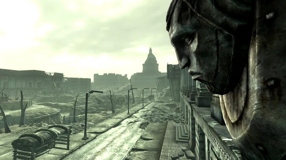 A ruined avenue leads toward the Capitol dome past a giant cracked statue head in Fallout 3's Capital Wasteland