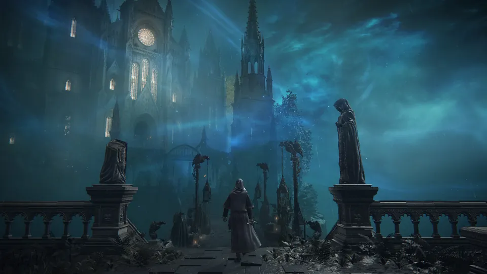 A hooded figure walks between statues toward a gothic castle under a blue night sky in Elden Ring Tarnished Edition on Nintendo Switch 2