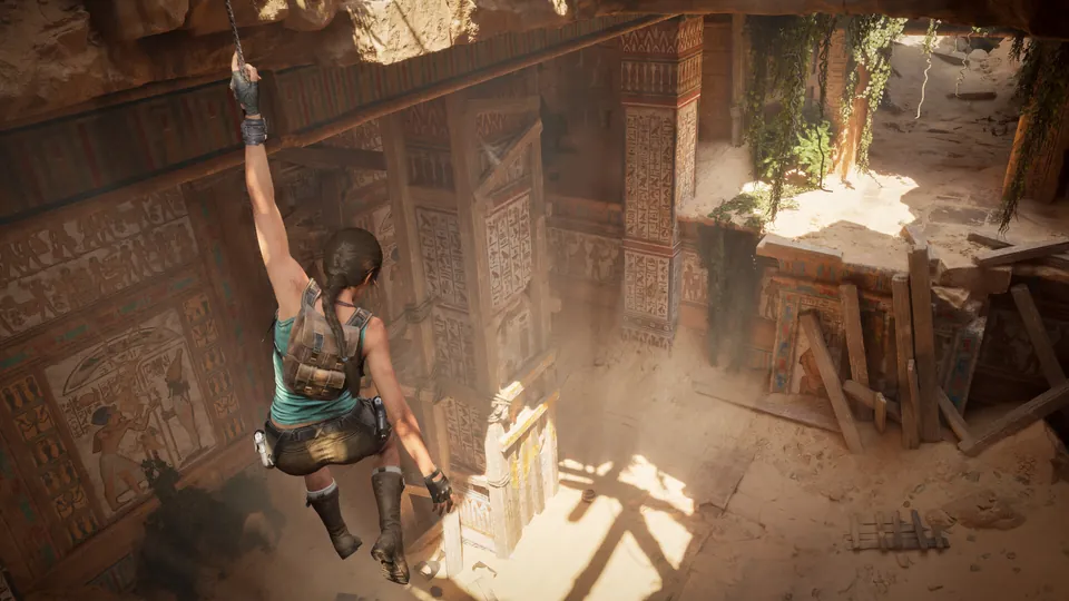 Lara Croft climbs a rope through a hole in the ceiling of a sandy Egyptian tomb in Tomb Raider: Legacy of Atlantis