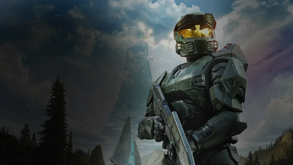 Halo's Master Chief in green armor stands before a Halo ring in key art from Microsoft's Xbox site