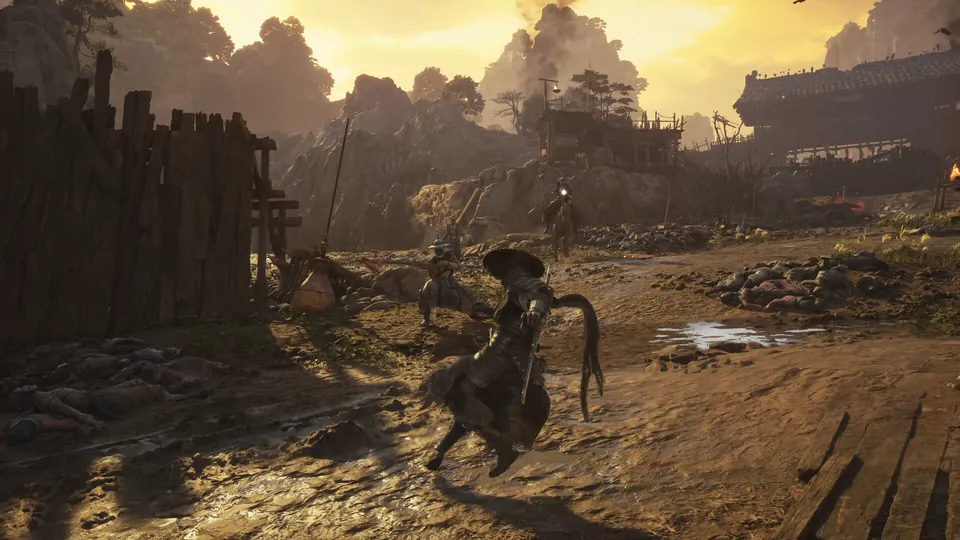 A fighter in a straw hat faces armed enemies on a dirt road outside a ruined village at sunset in Phantom Blade Zero