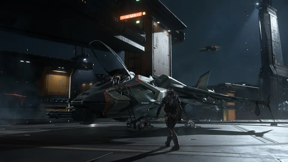 A pilot walks across a dark hangar toward a parked fighter in Squadron 42