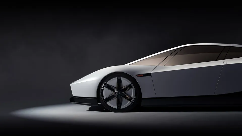 Side view of the low, wedge-shaped new Tesla Roadster in white on a dark stage